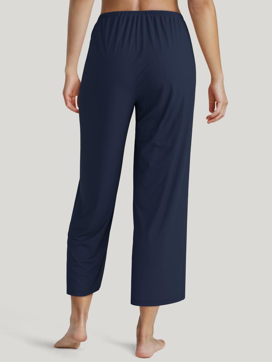 Damen-Model trägt 7/8-Pyjamahose aus Lyocell in Blau, Einfarbig aus Serie Favourites Xtra von CALIDA, Rückansicht, KI-generiertes Bild