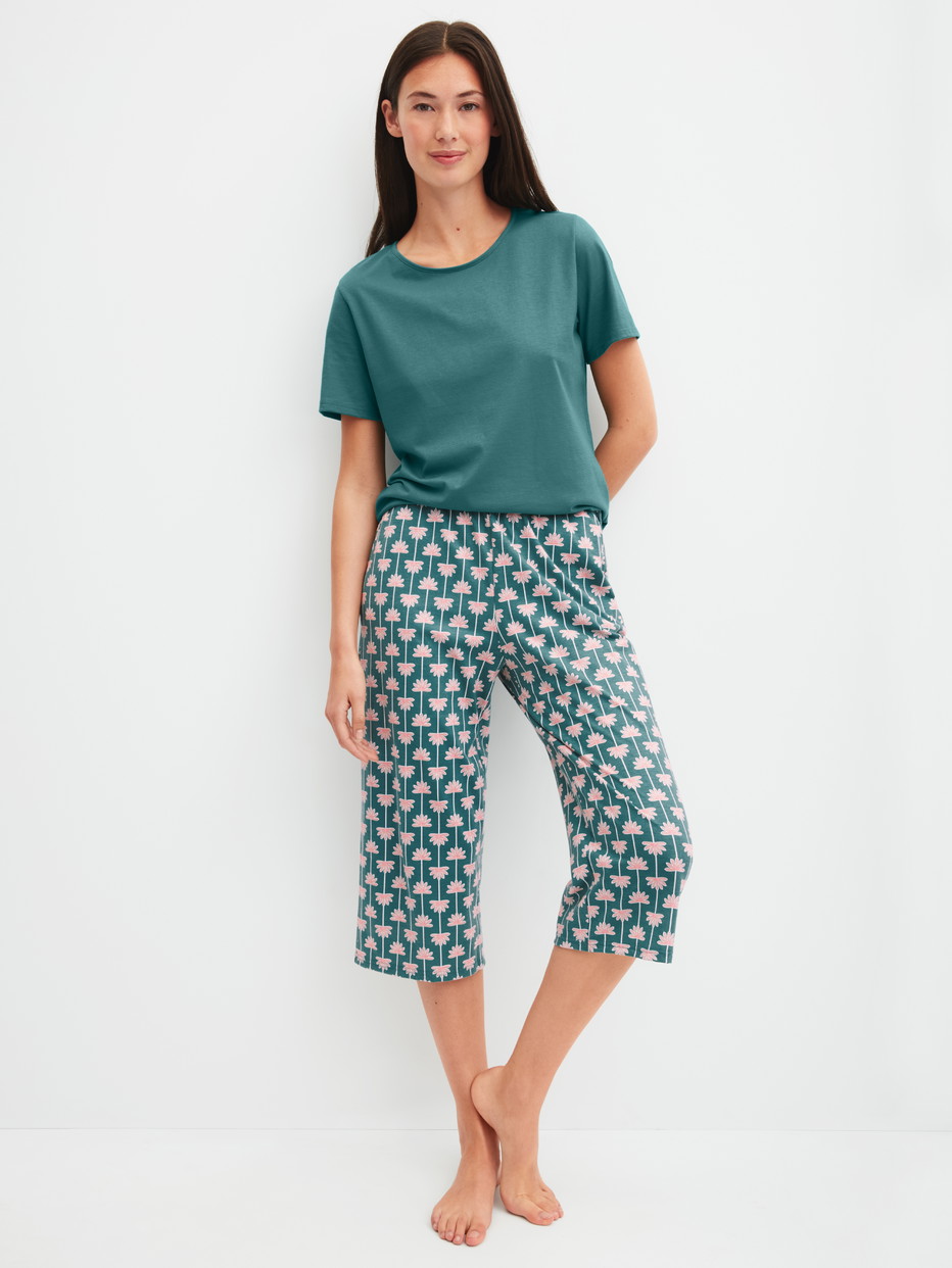 Damen-Model trägt 3/4-Pyjamahose aus 100% Baumwolle in Türkis, Gemustert aus Serie Favourites Beach von CALIDA, Outfit