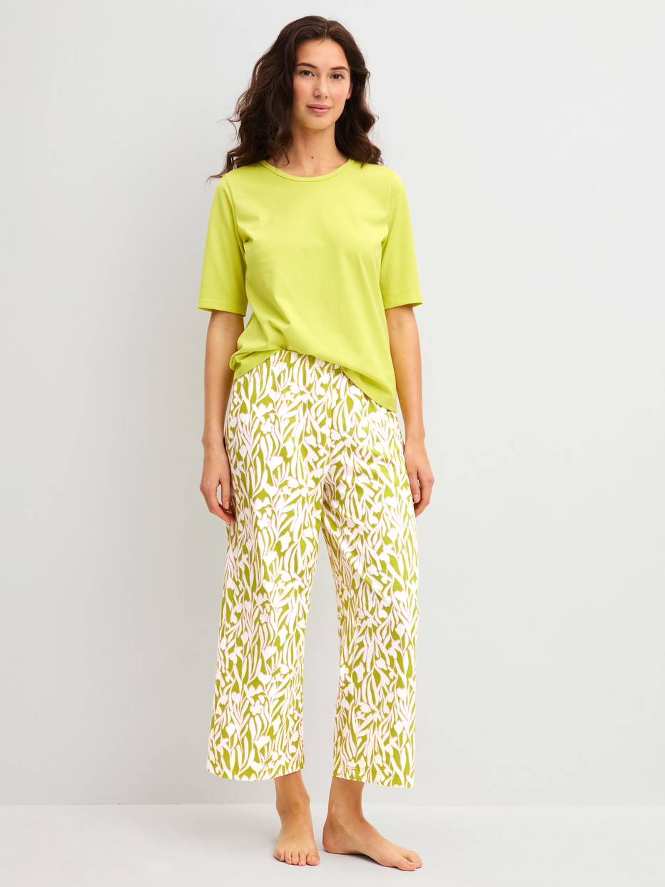 Damen-Model trägt 7/8-Pyjamahose aus 100% Baumwolle in Grün, Floral aus Serie Late Bloom M&M von CALIDA, Outfit
