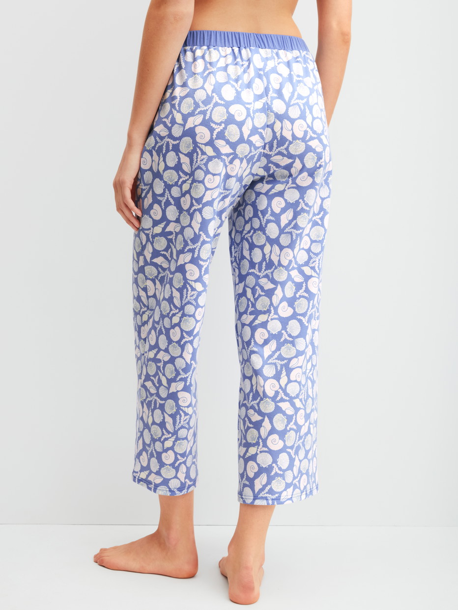 Damen-Model trägt 7/8-Pyjamahose aus 100% Baumwolle in Blau, Floral aus Serie Favourites Ocean von CALIDA, Rückansicht