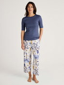 La modella / Il modello Donna indossa 7/8 pantaloni da pigiama in 100% cotone di colore Blu, Floreale, della serie Favourites Magic di CALIDA, Abbigliamento