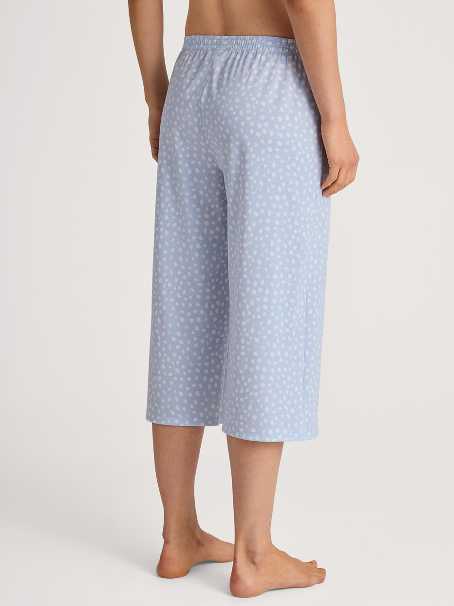 Women model is wearing 3/4 Pyjama bottom made of 100% Cotton in Blue, Patterned from the Favourites Sleep series by CALIDA, Back view