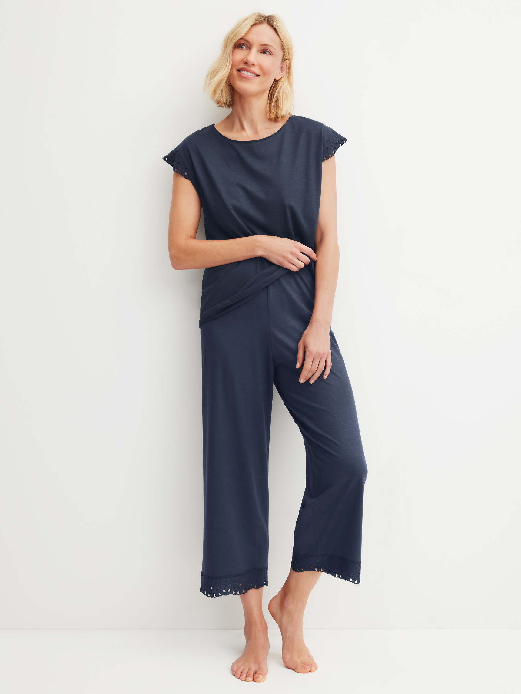 La modella / Il modello Donna indossa 7/8 Pantaloni pigiama in Cotone di colore Blu, Pizzo, della serie Favourites Tiles di CALIDA, Abbigliamento
