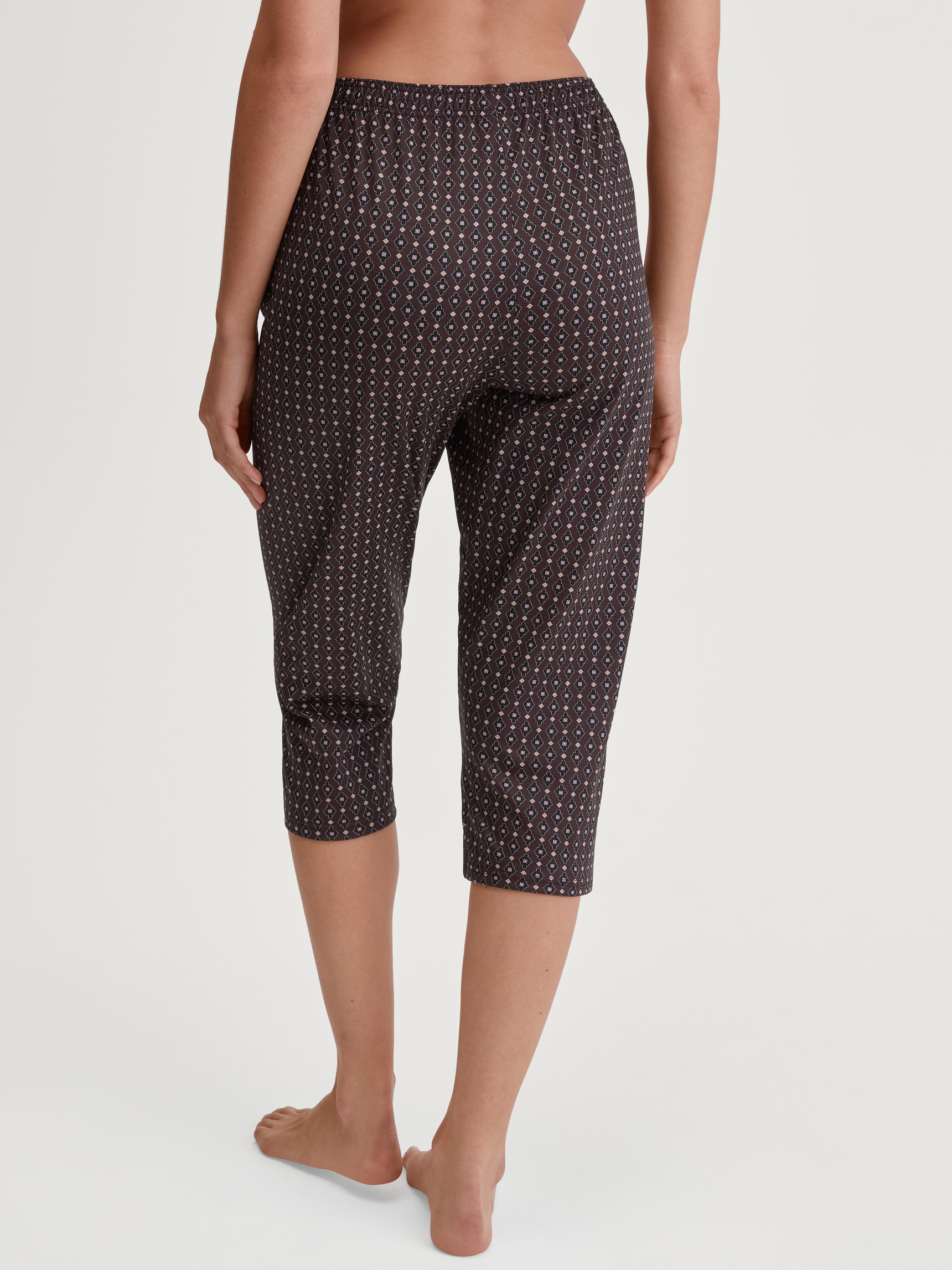 Damen-Model trägt 3/4-Pyjamahose aus 100% Baumwolle in Rot, Gemustert aus Serie Favourites Botanic von CALIDA, Rückansicht