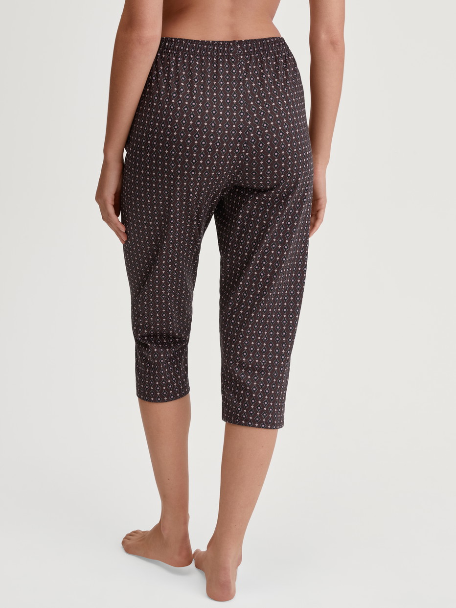 Damen-Model trägt 3/4-Pyjamahose aus 100% Baumwolle in Rot, Gemustert aus Serie Favourites Botanic von CALIDA, Rückansicht