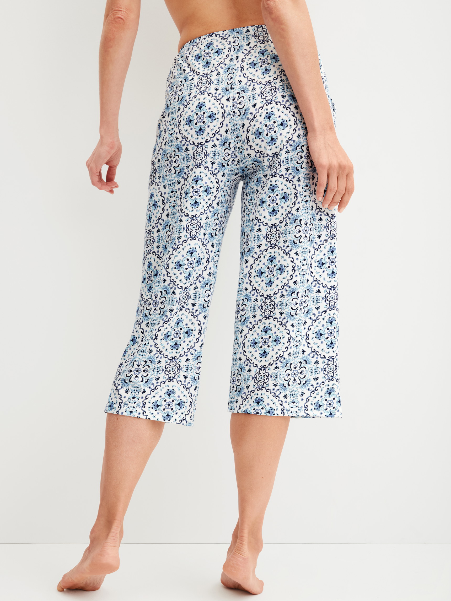 Damen-Model trägt 3/4-Pyjamahose aus 100% Baumwolle in Blau, Gemustert aus Serie Favourites Tiles von CALIDA, Rückansicht
