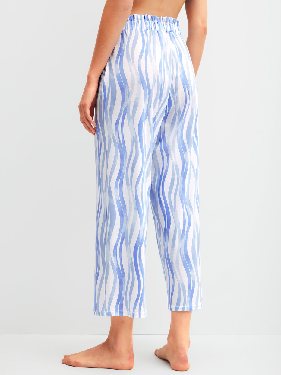 Damen-Model trägt 7/8-Pyjamahose aus Baumwolle in Blau, Gemustert aus Serie Favourites Ocean von CALIDA, Rückansicht