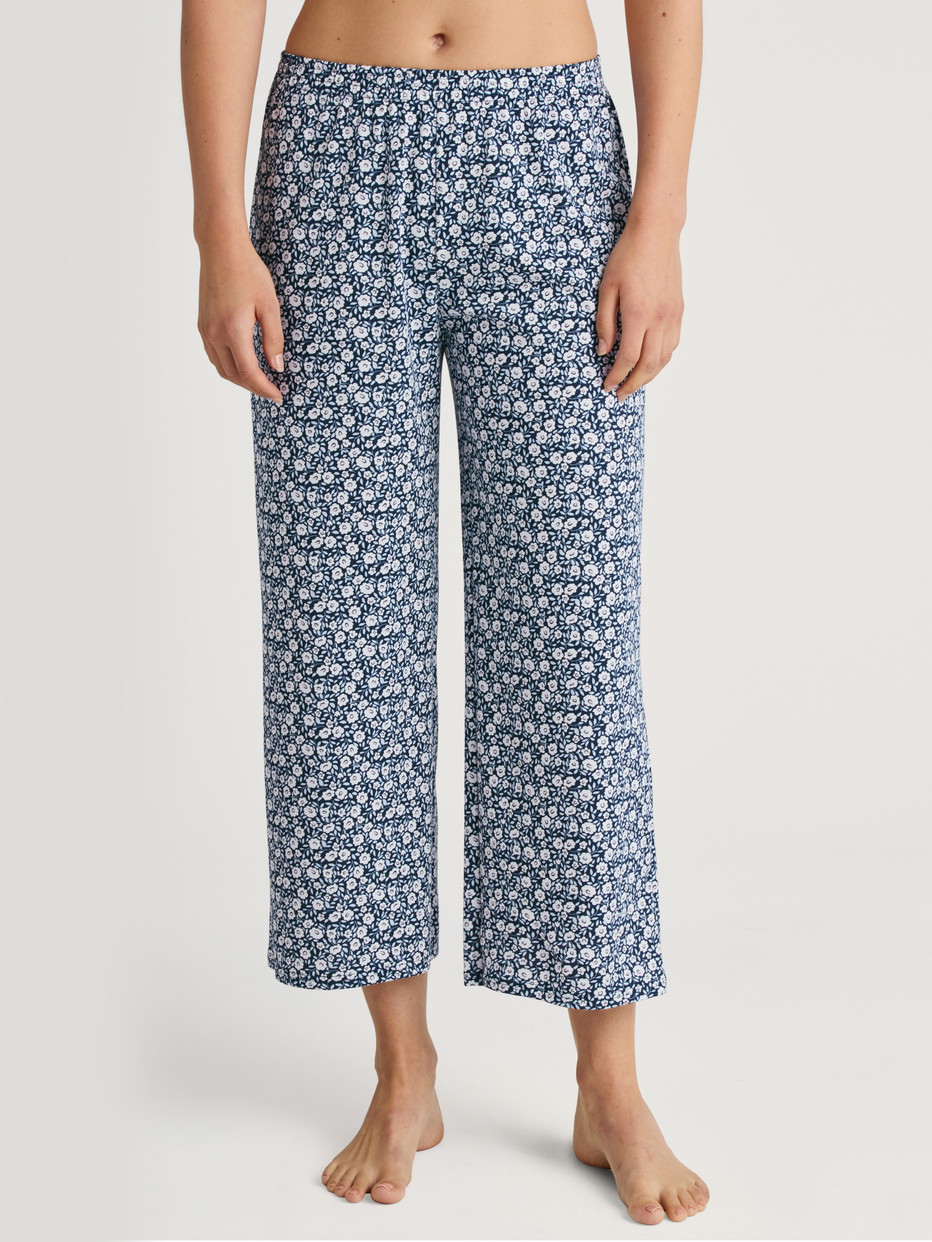 Women model is wearing 7/8 Pyjama bottom made of 100% Cotton in Blue, Floral from the Favourites Sleep series by CALIDA, Front view