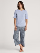 Damen-Model trägt 7/8-Pyjamahose aus 100% Baumwolle in Blau, Floral aus Serie Favourites Sleep von CALIDA, Outfit