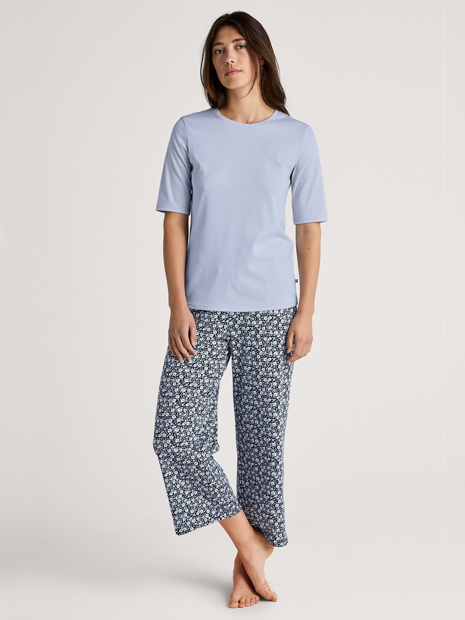 Women model is wearing 7/8 Pyjama bottom made of 100% Cotton in Blue, Floral from the Favourites Sleep series by CALIDA, Outfit
