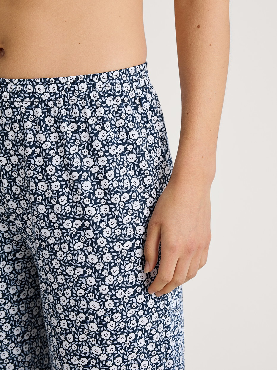 Women model is wearing 7/8 Pyjama bottom made of 100% Cotton in Blue, Floral from the Favourites Sleep series by CALIDA, Detail