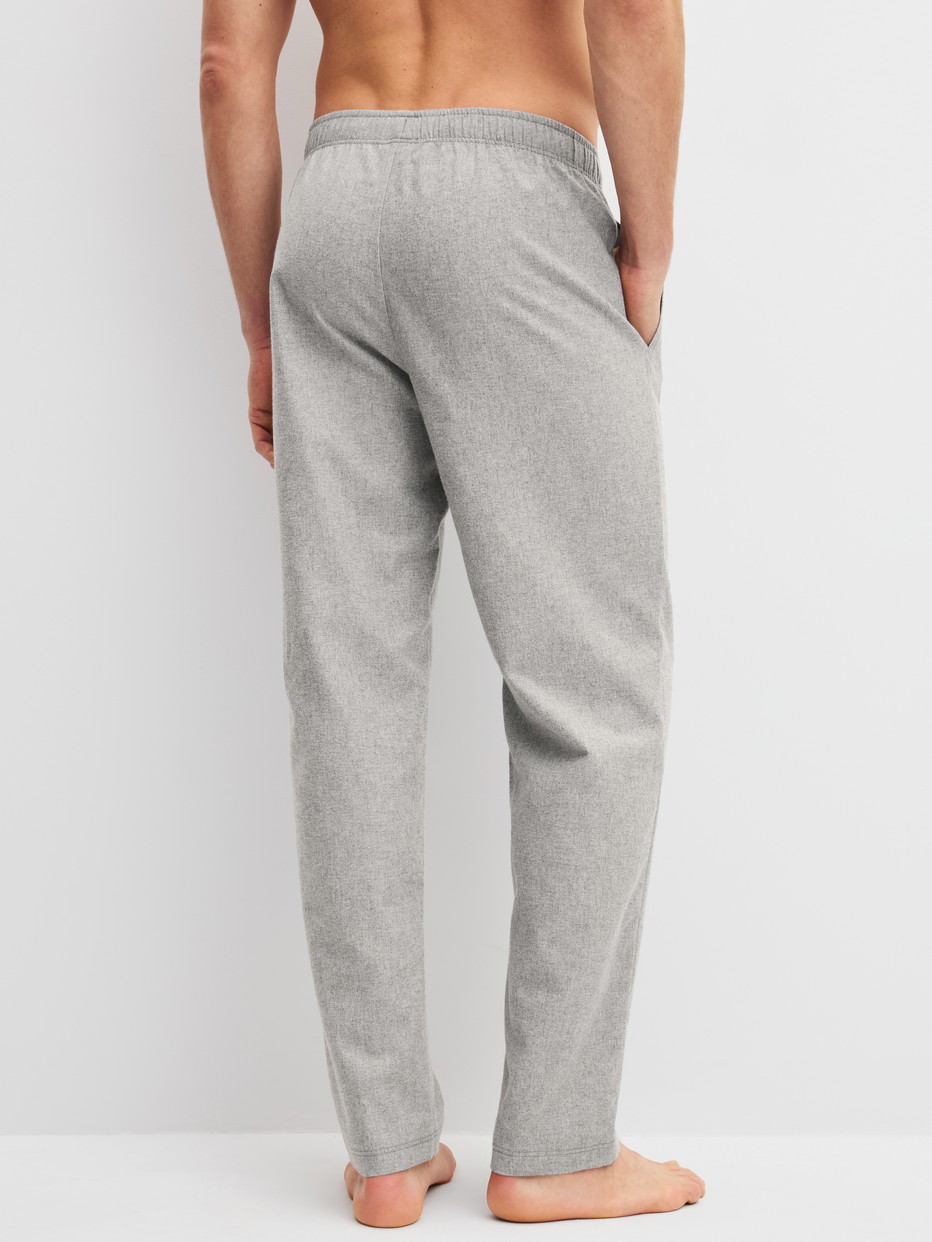 Herren-Model trägt Flanellhose mit Seitentaschen aus Flanell in Grau, Gemustert aus Serie RMX Flannel Mood von CALIDA, Rückansicht