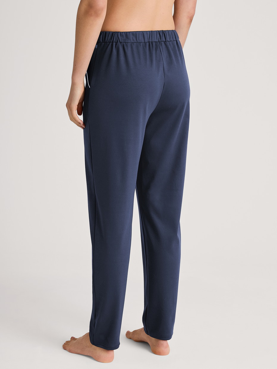 Women model is wearing Pyjama bottom made of 100% Cotton in Blue, Unicoloured from the Favourites Sleep series by CALIDA, Back view