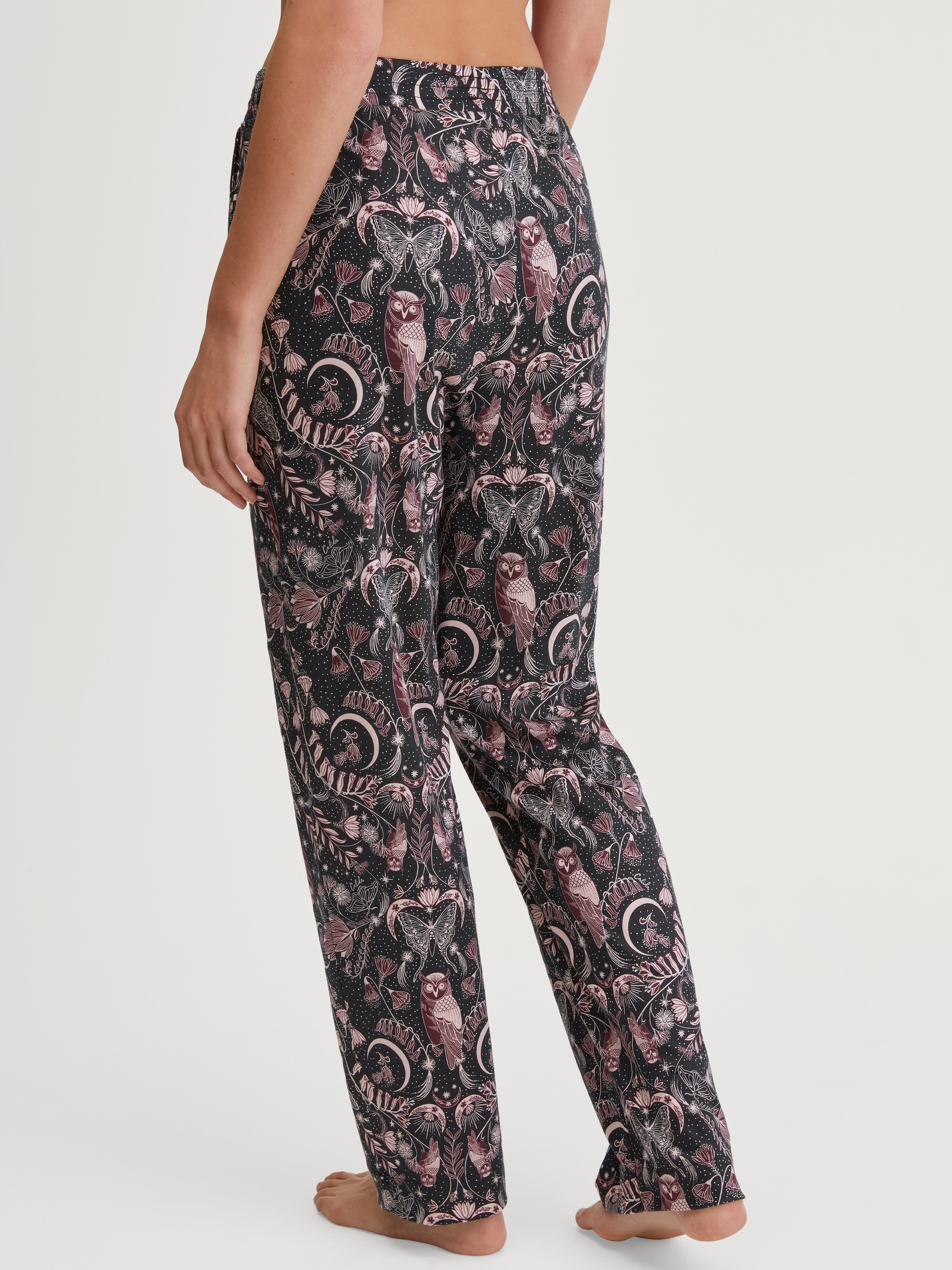 Women model is wearing Loungepants made from TENCEL™ modal and silk made of Modal in Black, Patterned from the Favourites Seduction series by CALIDA, Back view