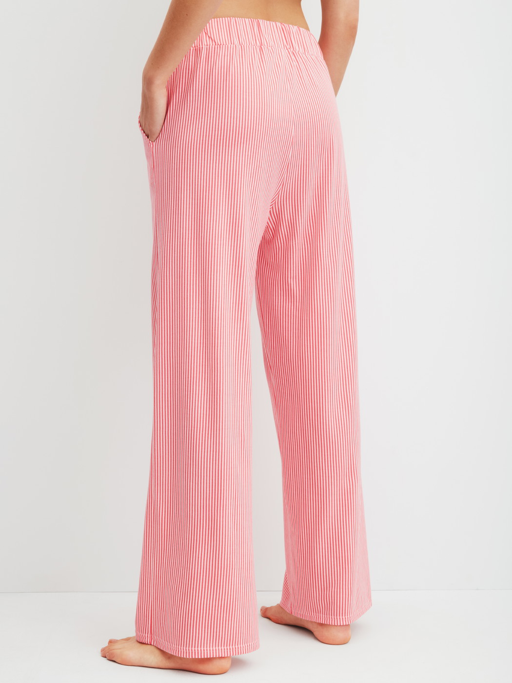 Damen-Model trägt Pyjamahose aus Baumwolle in Orange, Gestreift aus Serie Favourites Beach von CALIDA, Rückansicht