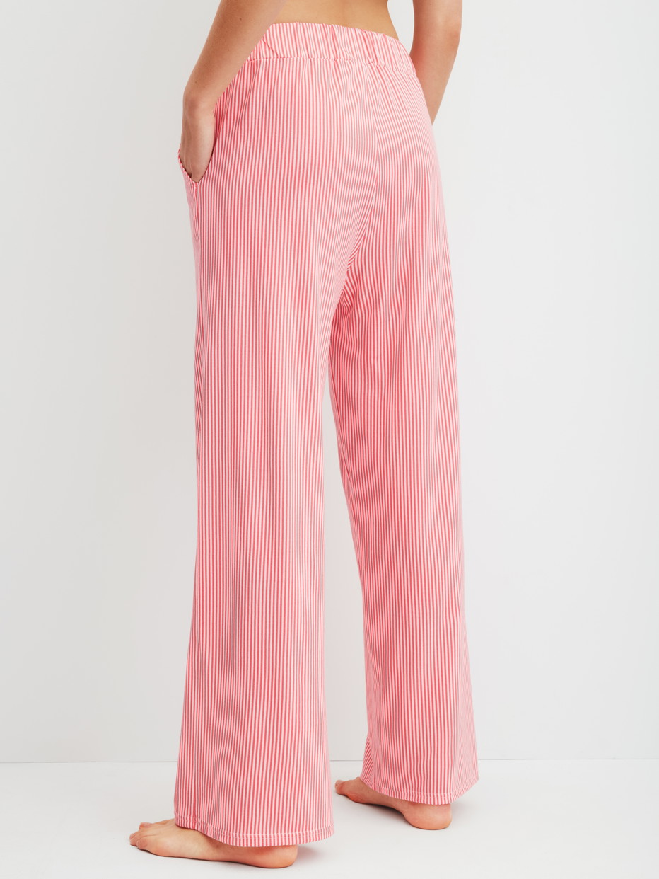Damen-Model trägt Pyjamahose aus Baumwolle in Orange, Gestreift aus Serie Favourites Beach von CALIDA, Rückansicht
