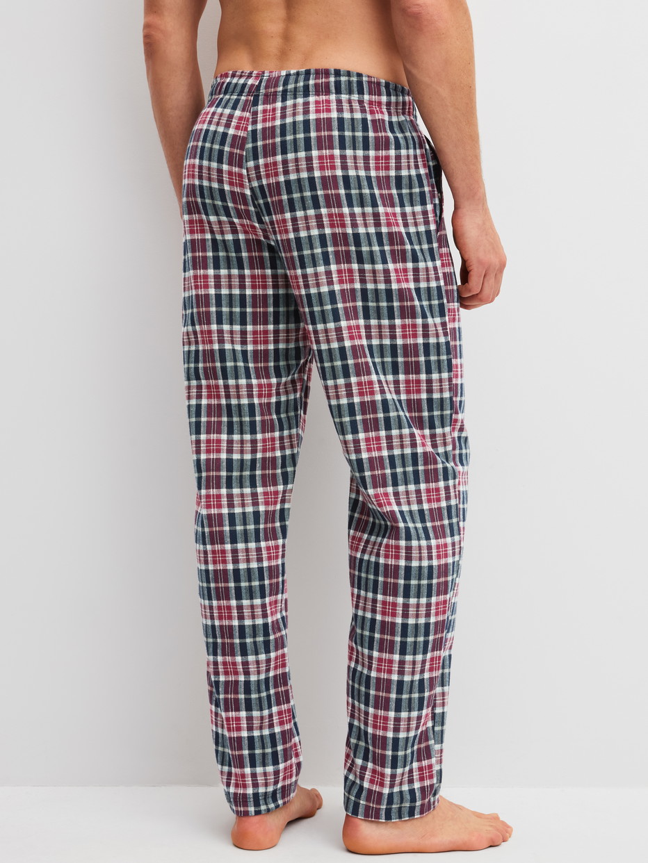 Herren-Model trägt Flannel-Pyjamahose mit Seitentaschen aus 100% Baumwolle in Blau, Kariert aus Serie Family & Friends von CALIDA, Rückansicht