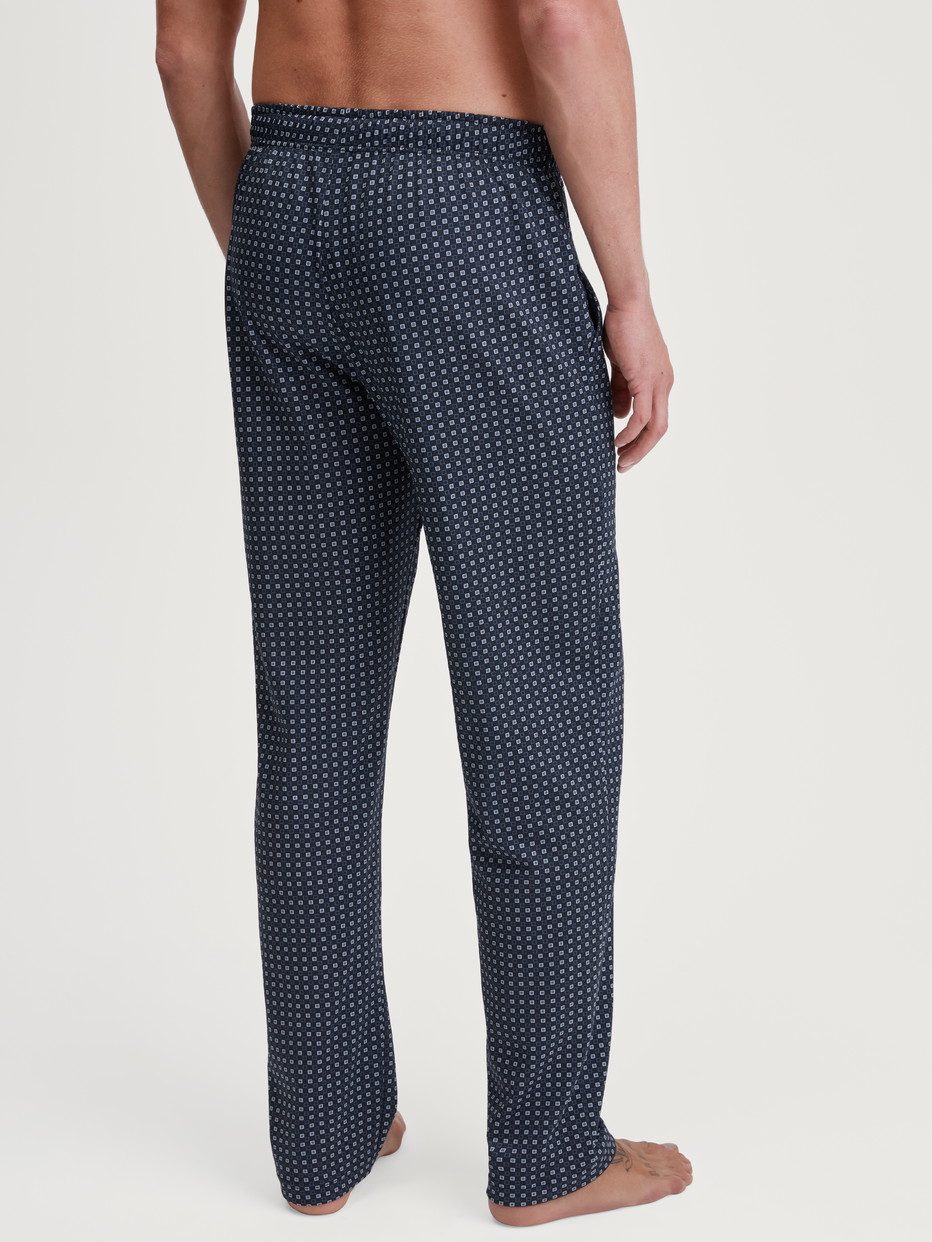Herren-Model trägt Pyjamahose mit Seitentaschen aus 100% Baumwolle in Blau, Kariert aus Serie Remix Basic Sleep von CALIDA, Rückansicht