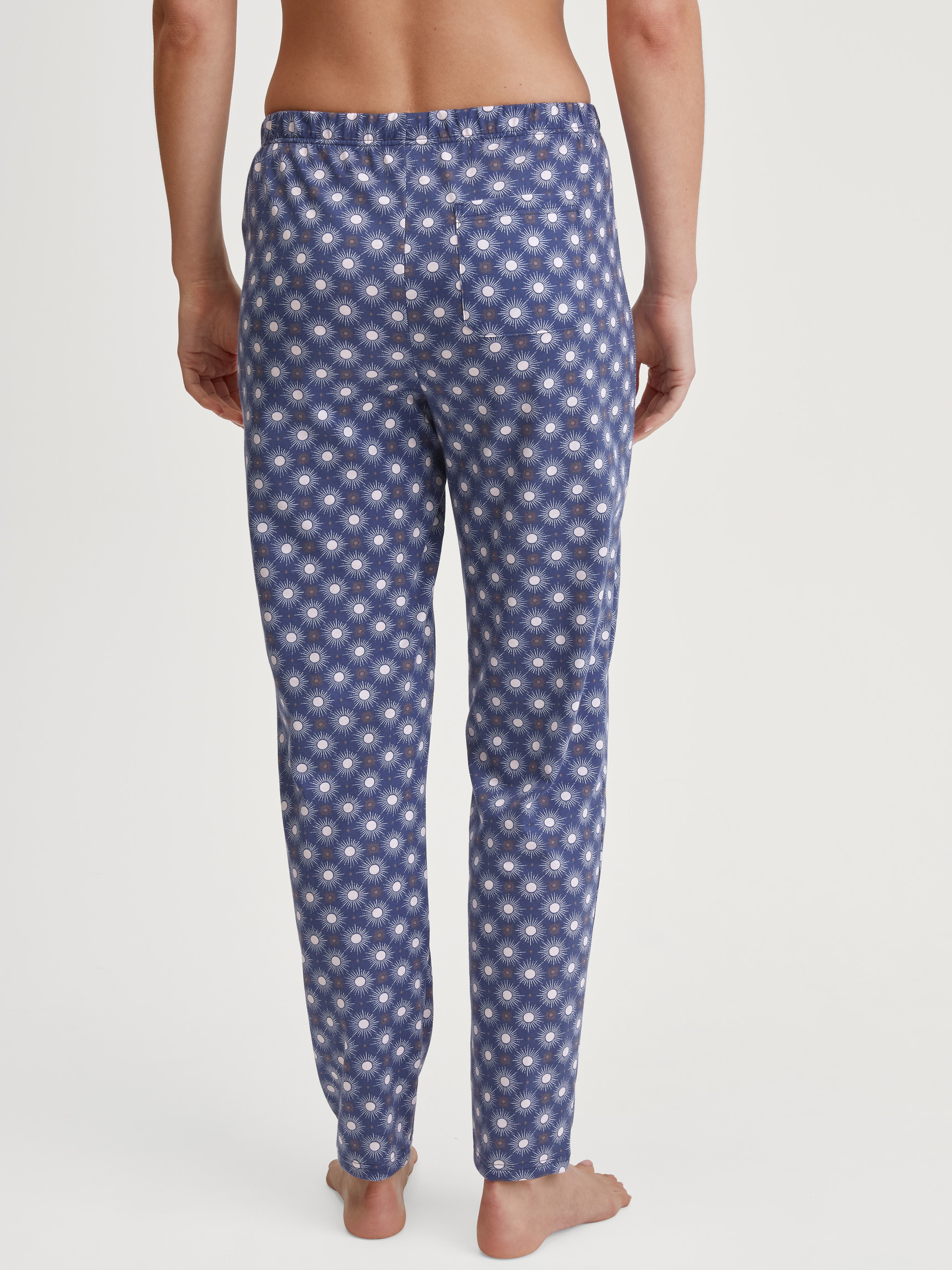 Damen-Model trägt Pyjamahose aus 100% Baumwolle in Blau, Gemustert aus Serie Favourites Universe von CALIDA, Rückansicht