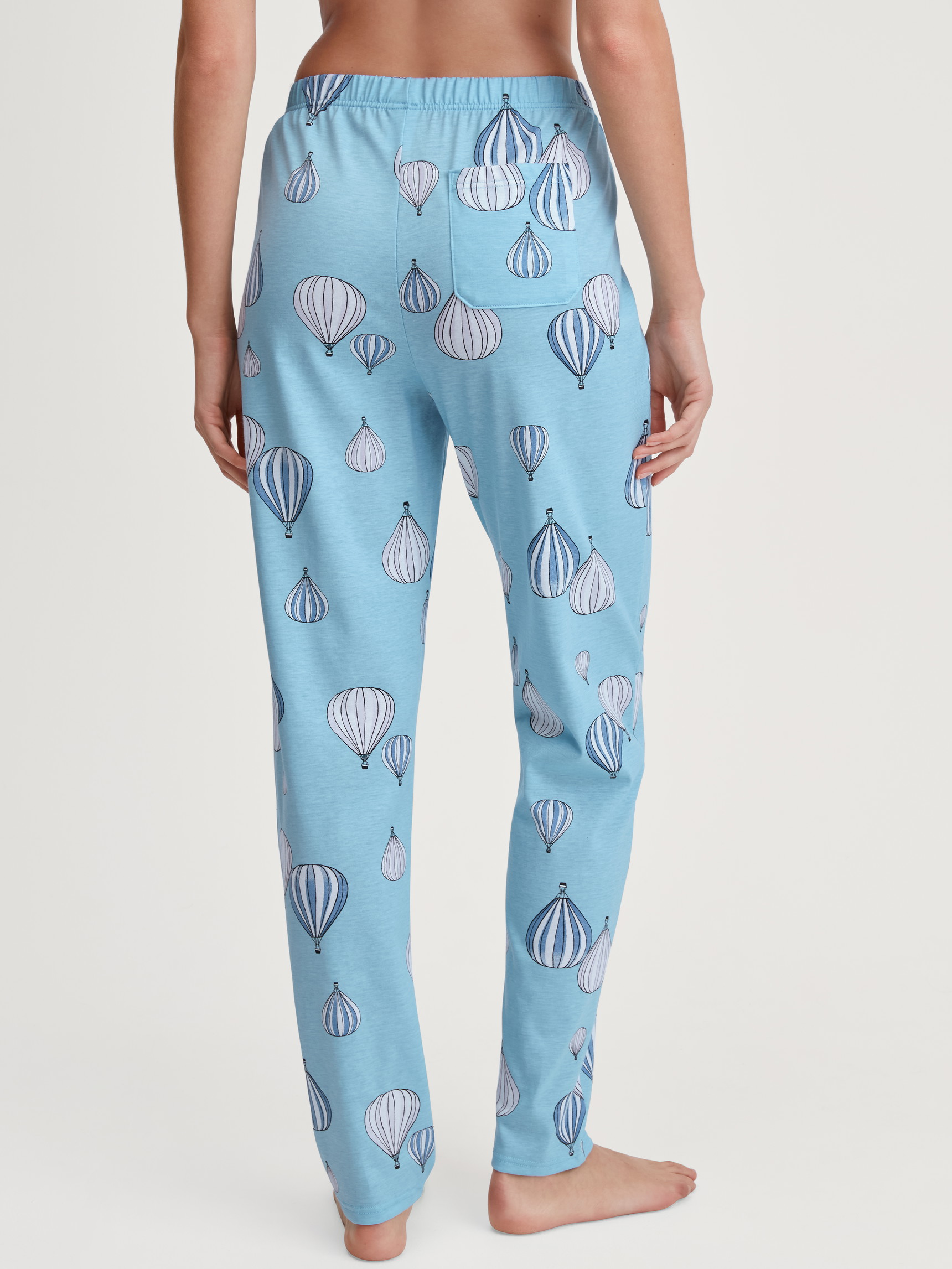 Damen-Model trägt Pyjamahose aus 100% Baumwolle in Blau, Gemustert aus Serie Favourites Journey von CALIDA, Rückansicht