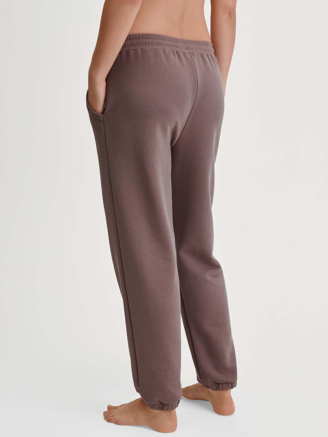 Damen-Model trägt Loungehose mit Seitentaschen aus Baumwolle in Braun, Einfarbig aus Serie Lounge Element von CALIDA, Rückansicht