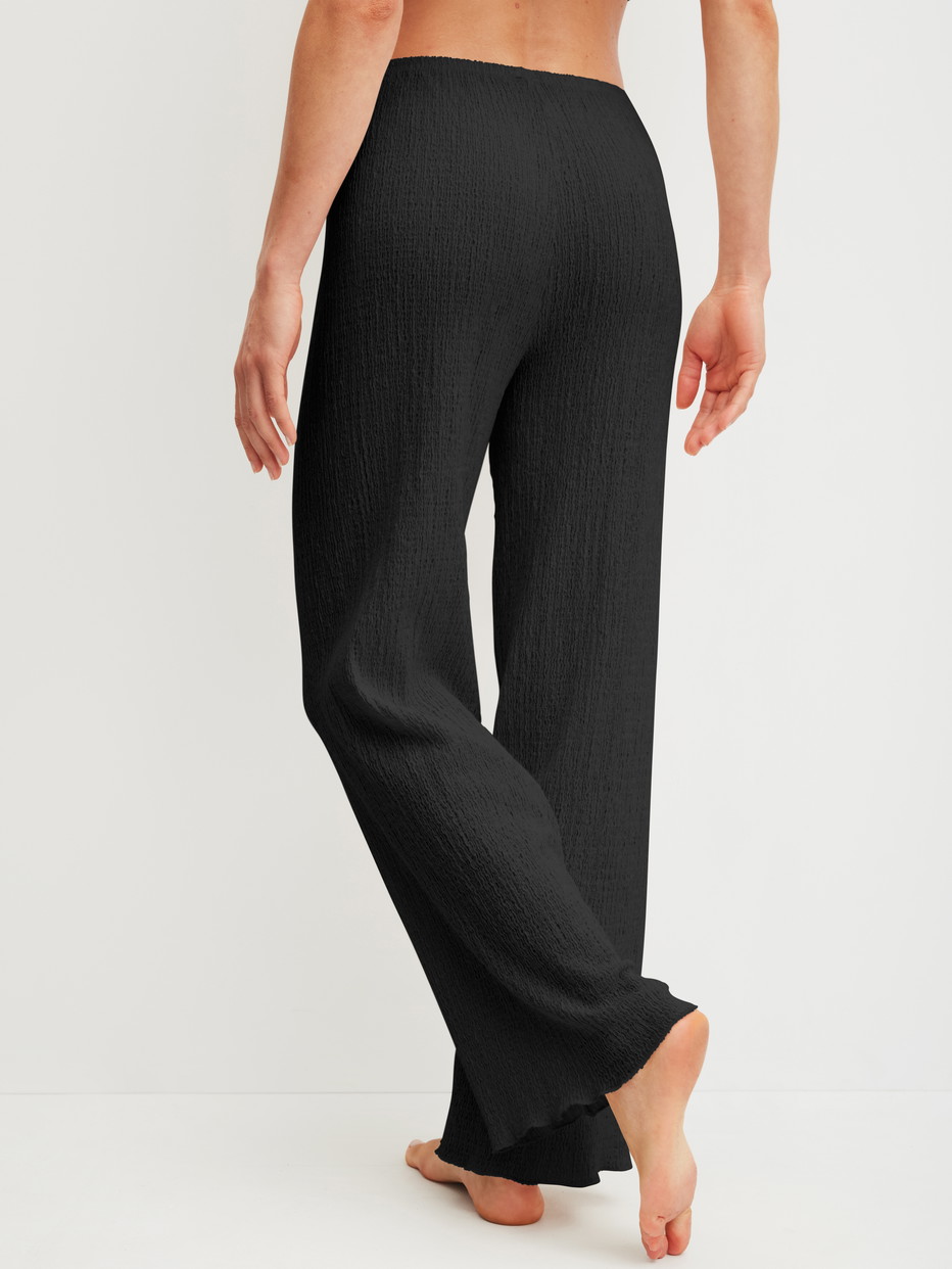Damen-Model trägt Pyjamahose aus Baumwolle in Schwarz, Einfarbig aus Serie Favourites Layering von CALIDA, Rückansicht
