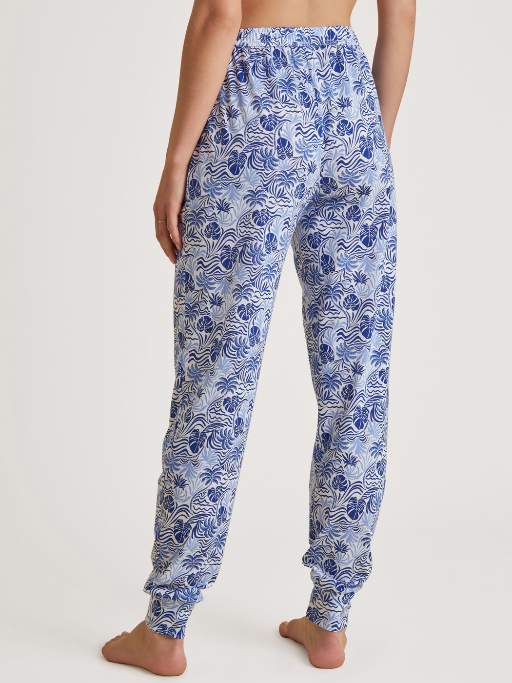 Damen-Model trägt Pants mit Bündchen aus Modal in Blau, Floral aus Serie Favourites Serenity von CALIDA, Rückansicht