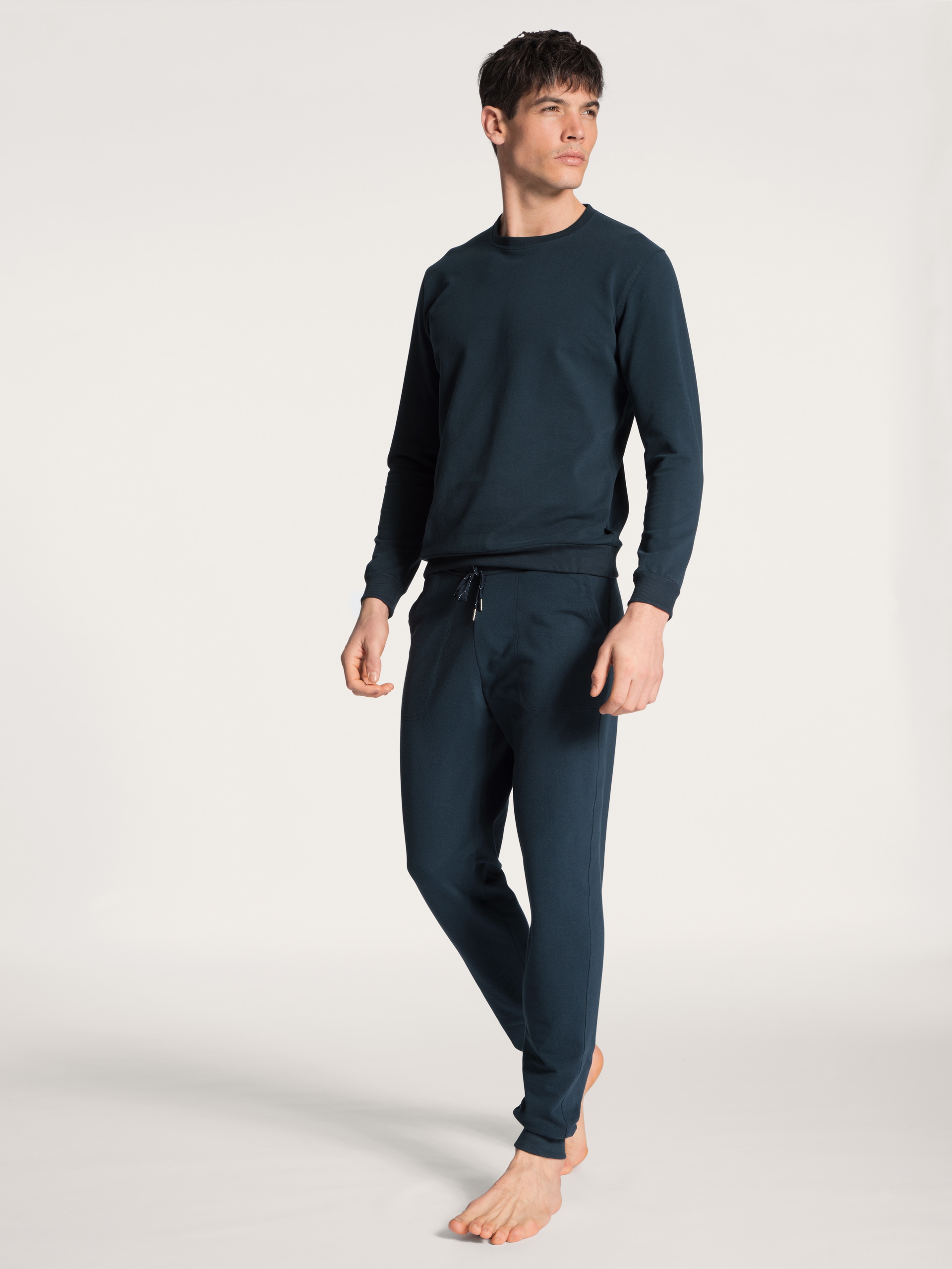 Men model is wearing Jogging pants with side pockets made of Cotton in Blue, Unicoloured from the Remix Basic Lounge series by CALIDA, Outfit, Front view