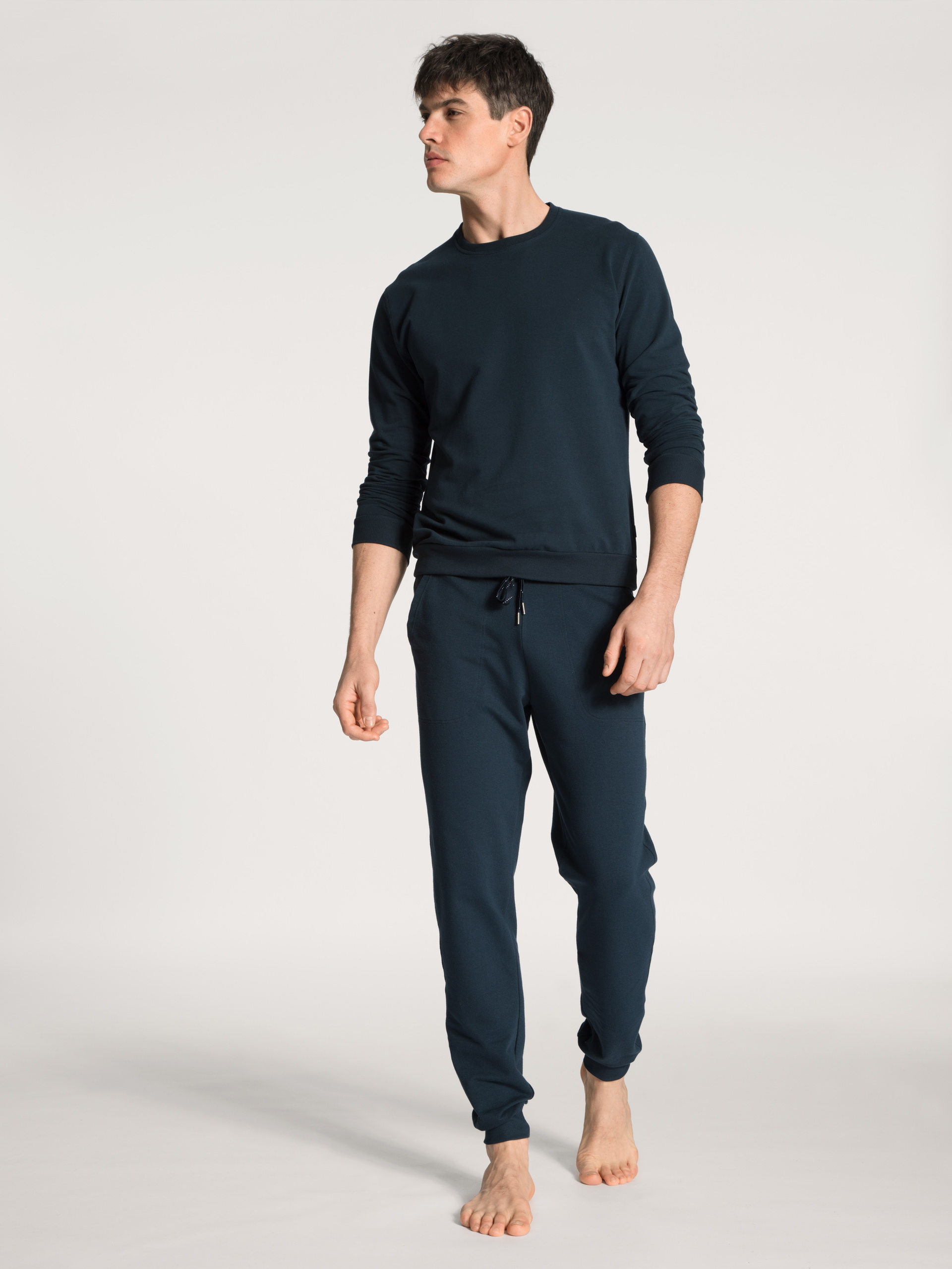 Men model is wearing Jogging pants with side pockets made of Cotton in Blue, Unicoloured from the Remix Basic Lounge series by CALIDA, Outfit, Front view