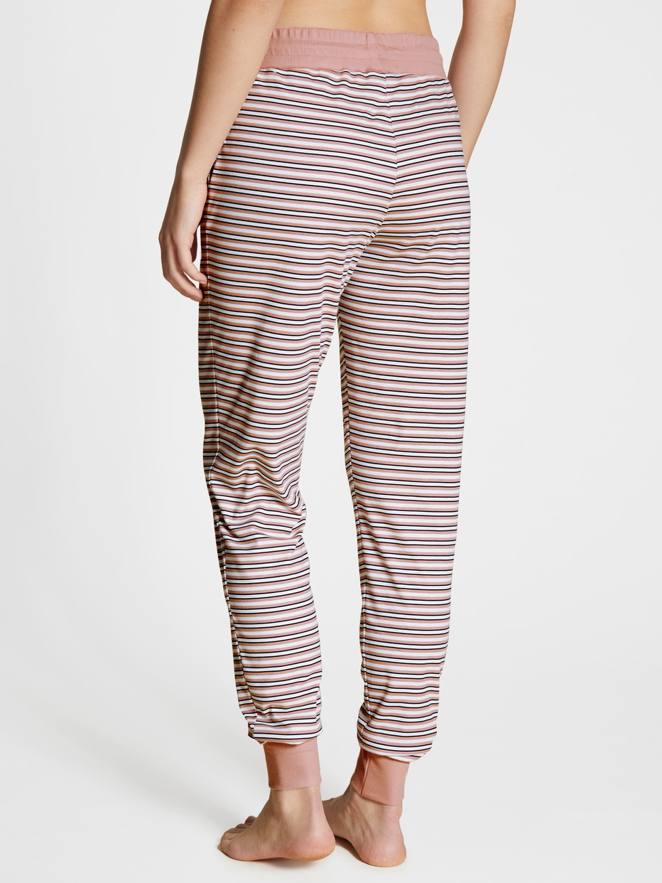 Damen-Model trägt Pyjamahose mit Seitentaschen aus 100% Baumwolle in Rosa, Gestreift aus Serie Favourites Dreams von CALIDA, Rückansicht