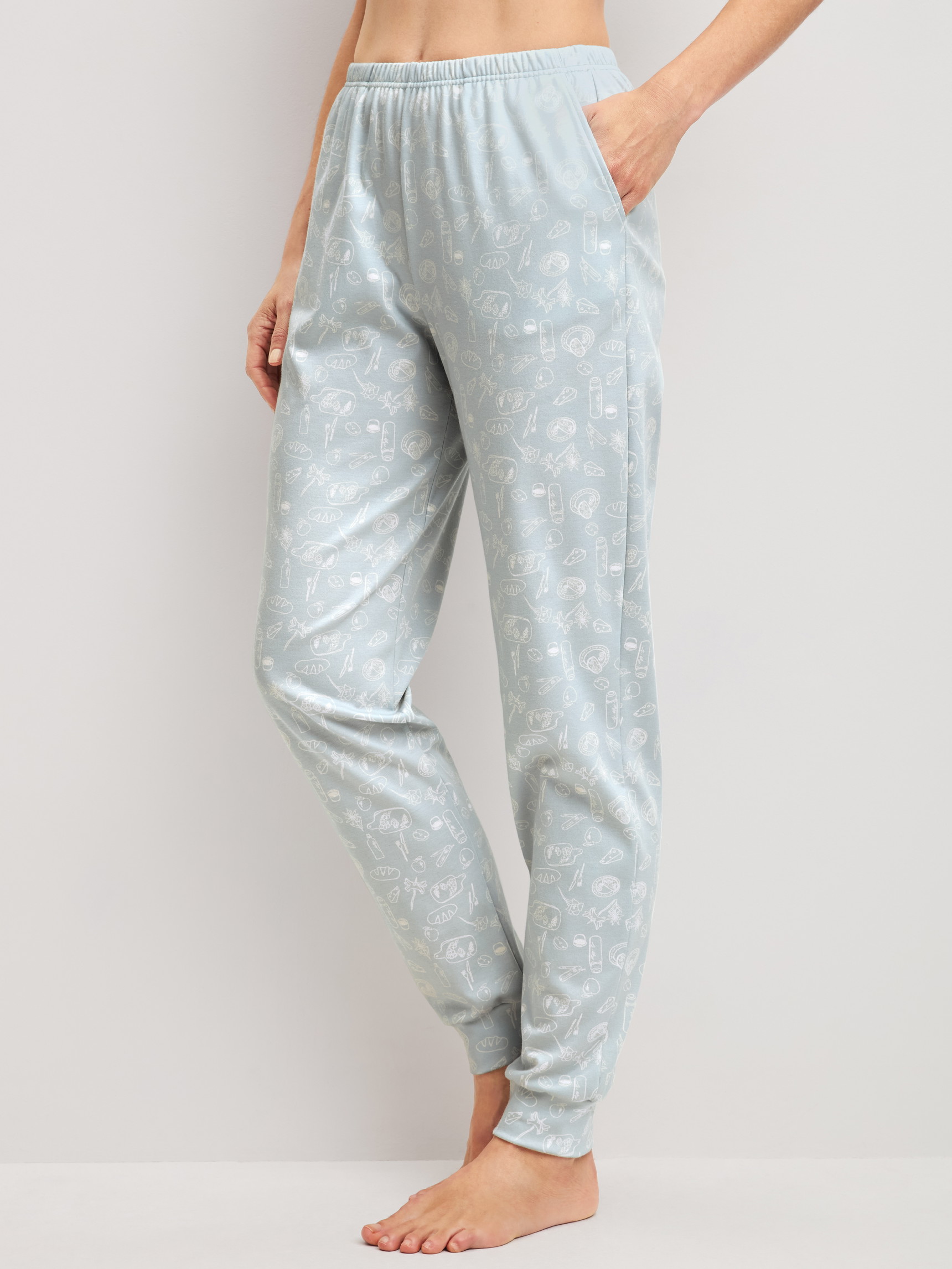 Women model is wearing Pyjama bottoms with cuffs made of 100% Cotton in Blue, Patterned from the Alpine M&M series by CALIDA, Front view