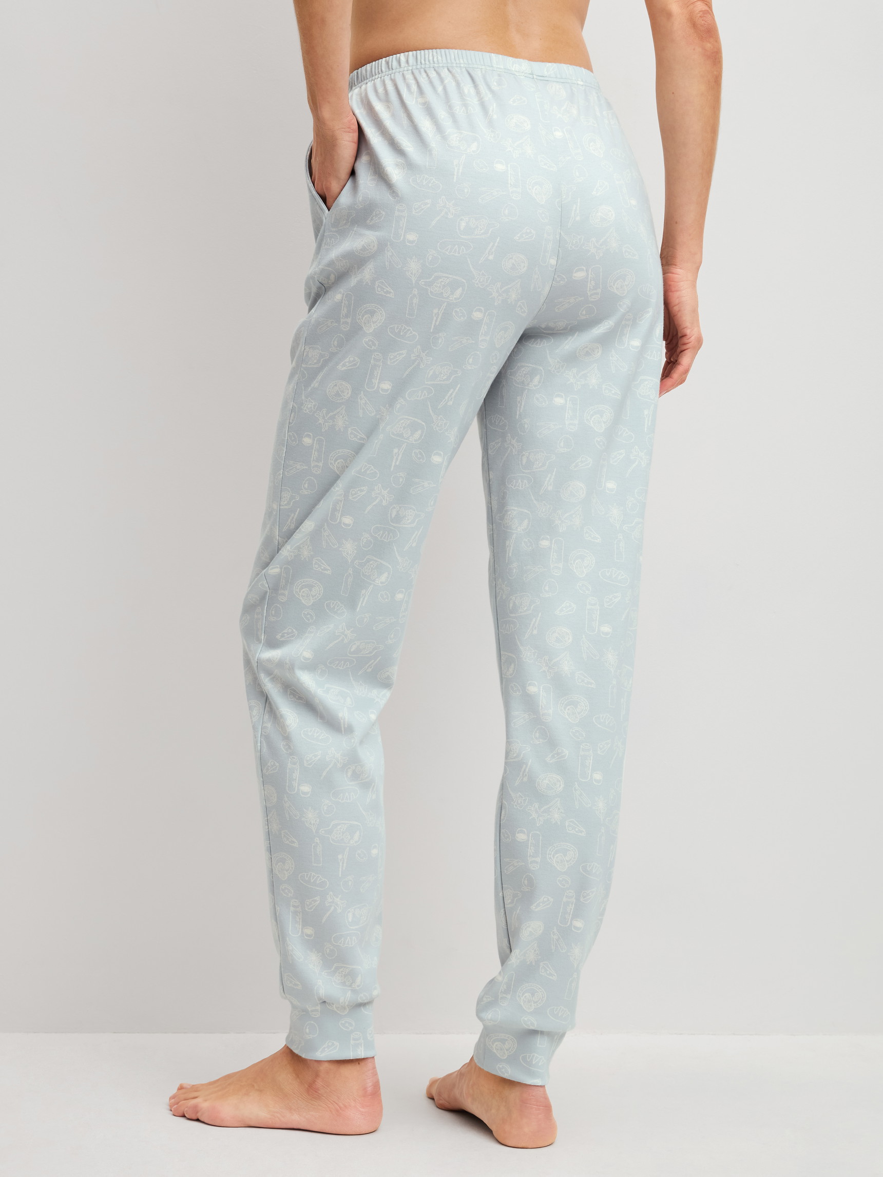 Women model is wearing Pyjama bottoms with cuffs made of 100% Cotton in Blue, Patterned from the Alpine M&M series by CALIDA, Back view