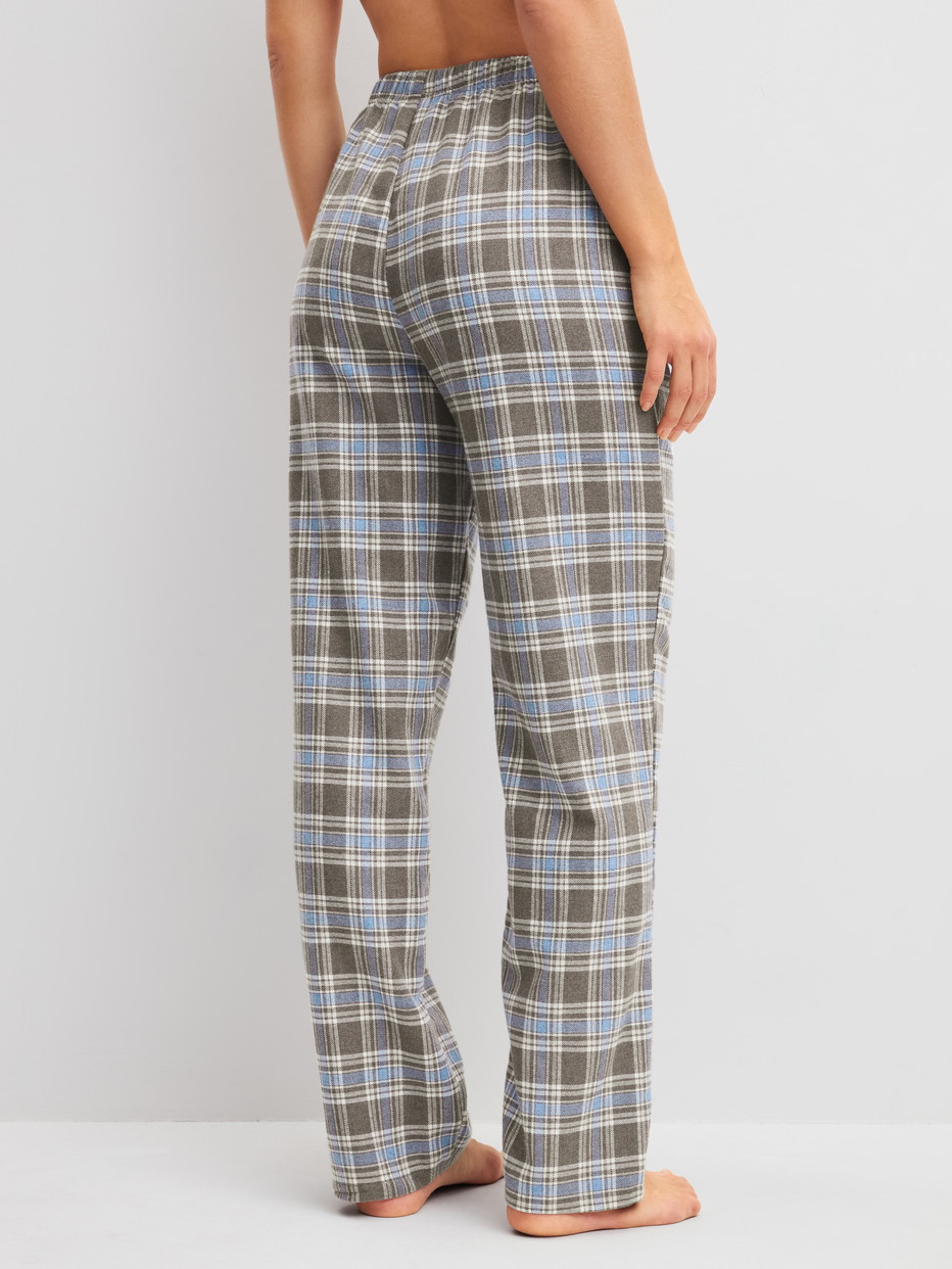 Damen-Model trägt Flannellhose mit Seitentaschen aus Baumwolle in Blau, Kariert aus Serie Alpine M&M von CALIDA, Rückansicht
