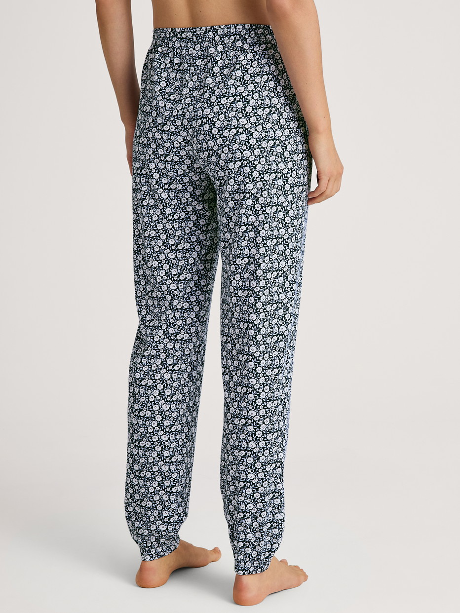 Women model is wearing Pyjama bottom with cuffs made of 100% Cotton in Blue, Floral from the Favourites Sleep series by CALIDA, Back view