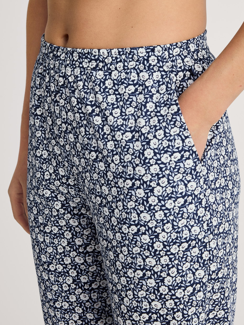 Women model is wearing Pyjama bottom with cuffs made of 100% Cotton in Blue, Floral from the Favourites Sleep series by CALIDA, Detail