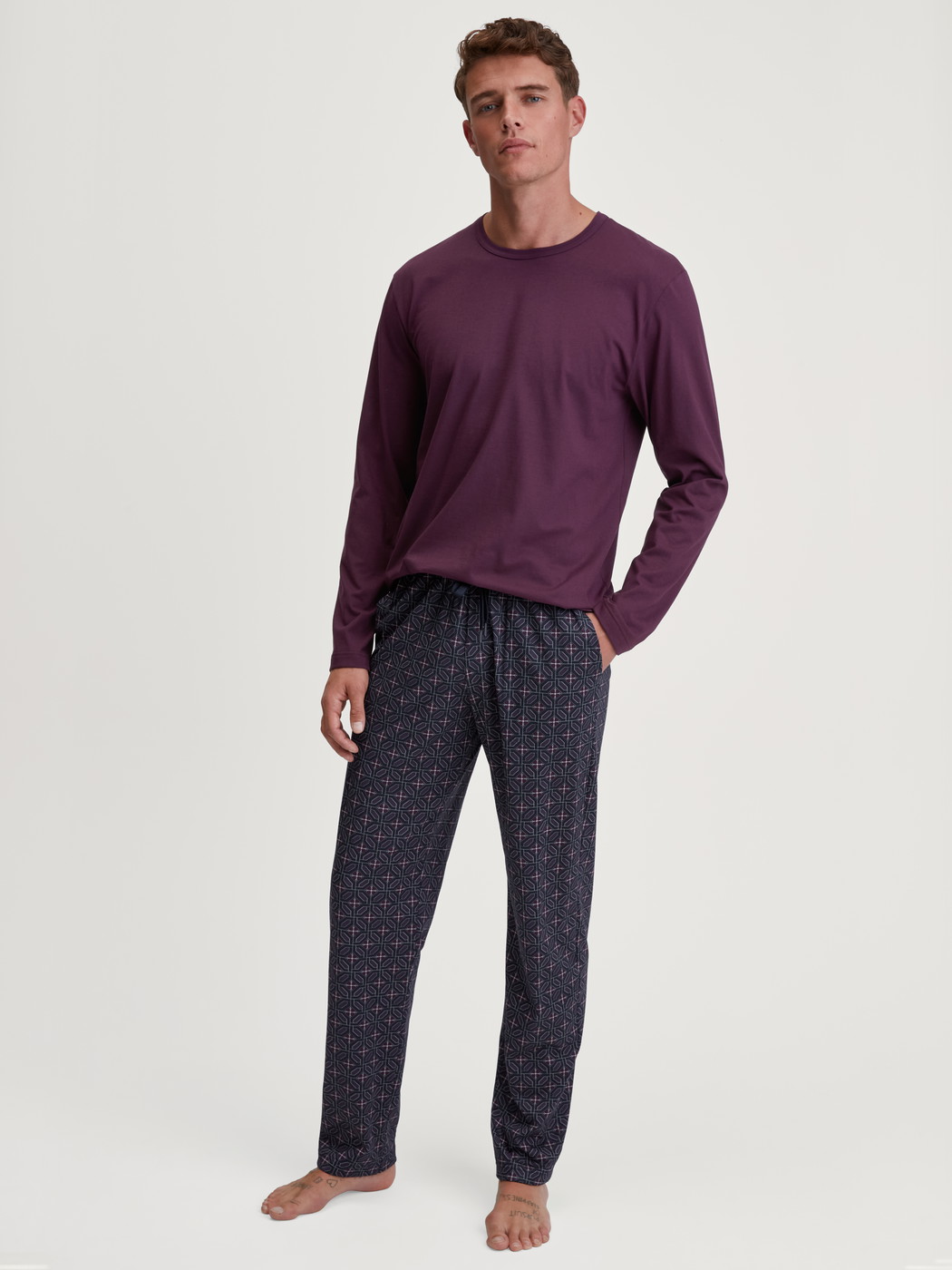 La modella / Il modello Uomo indossa Pantaloni da notte con tasche in 100% cotone di colore Marrone, Modello, della serie RMX Sleep Holiday di CALIDA, Abbigliamento