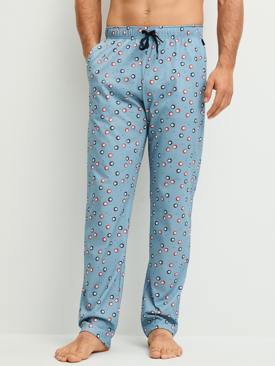 Herren-Model trägt Pyjamahose mit Seitentaschen aus 100% Baumwolle in Blau, Gemustert aus Serie RMX Sleep Holiday von CALIDA, Vorderansicht