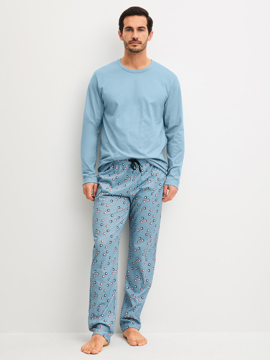 Herren-Model trägt Pyjamahose mit Seitentaschen aus 100% Baumwolle in Blau, Gemustert aus Serie RMX Sleep Holiday von CALIDA, Outfit