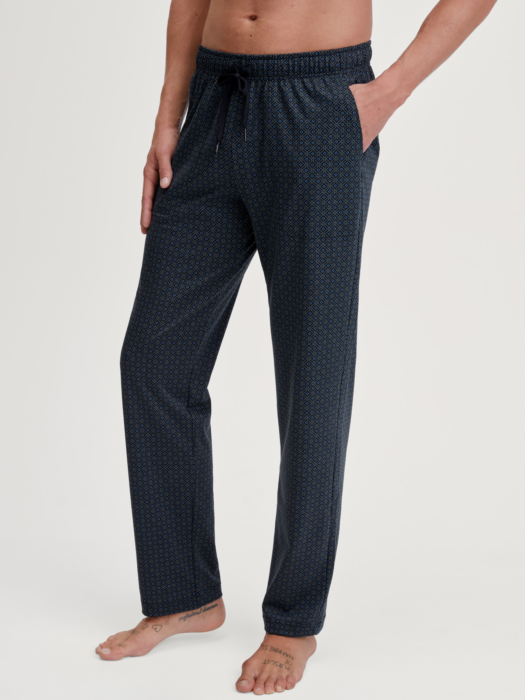 Men model is wearing Pyjama Bottoms with Side Pockets made of 100% Cotton in Blue, Patterned from the RMX Sleep Weekend series by CALIDA, Front view
