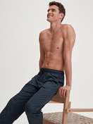 Men model is wearing Pyjama Bottoms with Side Pockets made of 100% Cotton in Blue, Patterned from the RMX Sleep Weekend series by CALIDA, Front view