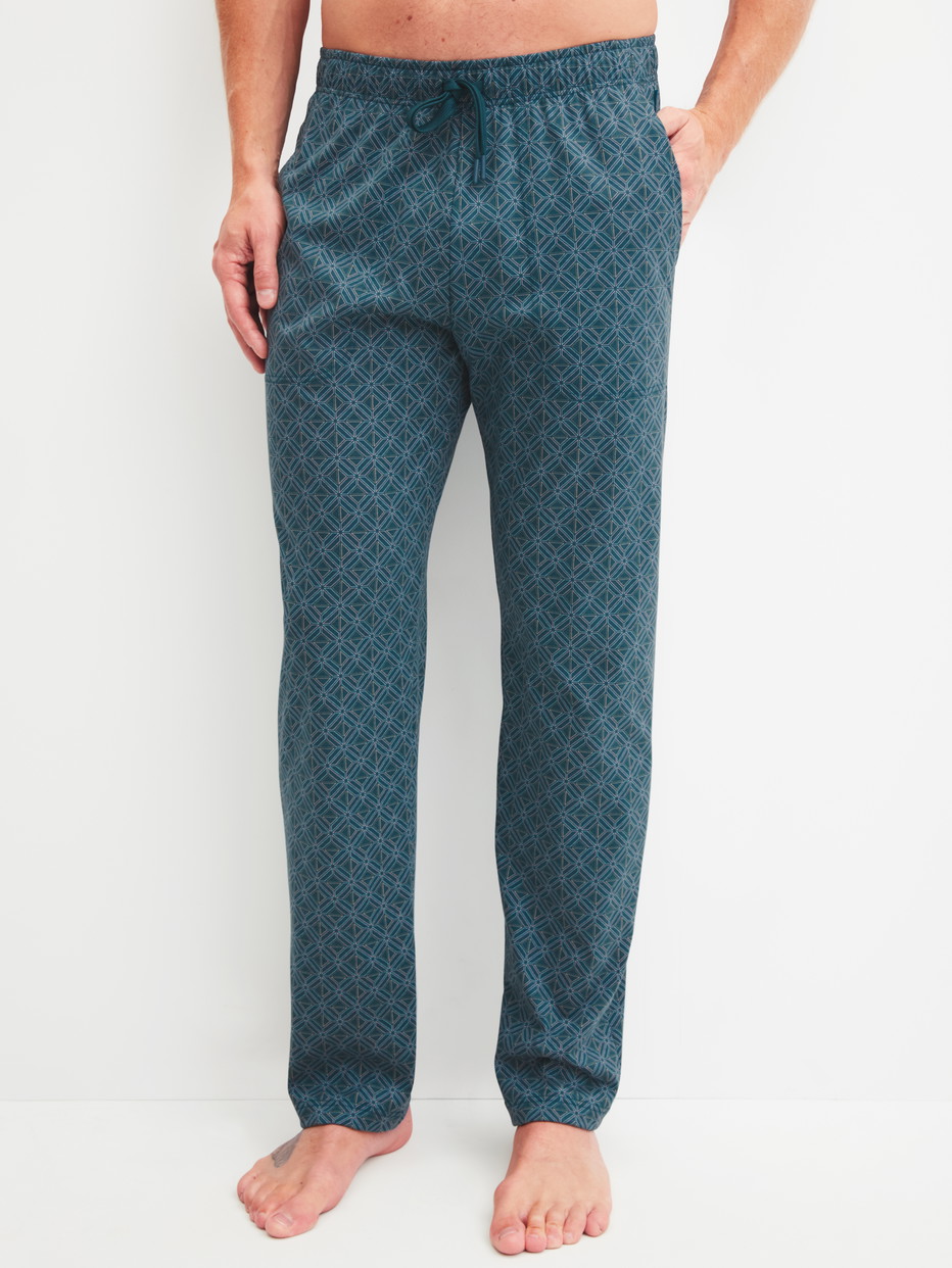Herren-Model trägt Pyjamahose mit Seitentaschen aus 100% Baumwolle in Türkis, Gemustert aus Serie RMX Sleep Leisure von CALIDA, Vorderansicht