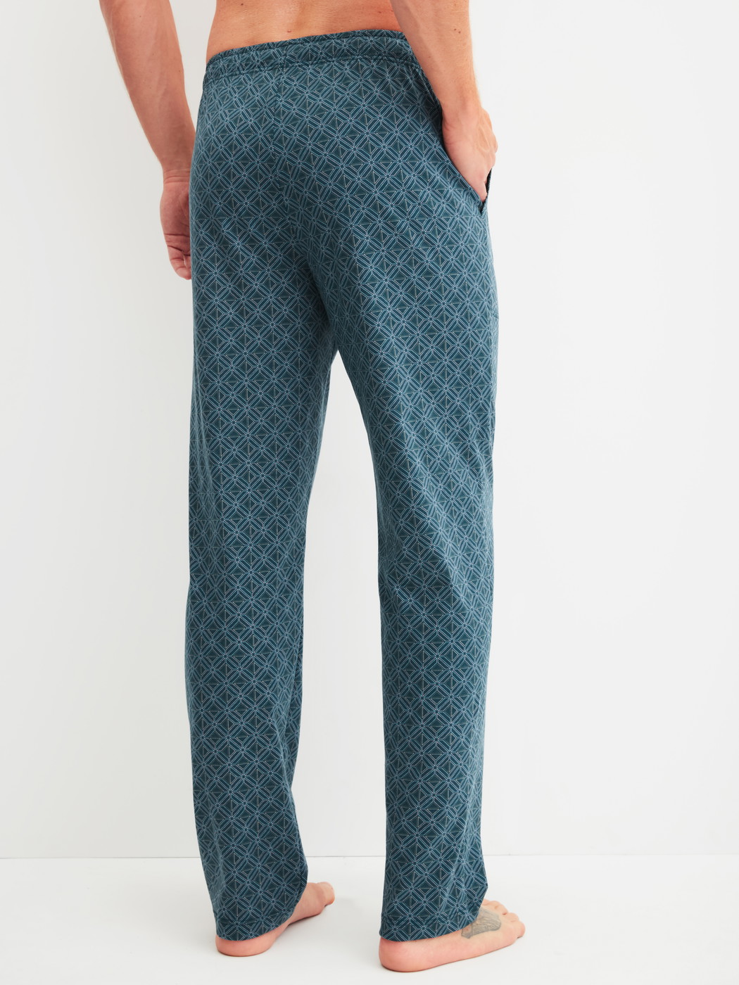 Men model is wearing Pyjama Bottoms with Side Pockets made of 100% Cotton in Turquoise, Patterned from the RMX Sleep Leisure series by CALIDA, Back view