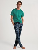 Herren-Model trägt Pyjamahose mit Seitentaschen aus 100% Baumwolle in Blau, Motiv aus Serie RMX Sleep Weekend von CALIDA, Outfit