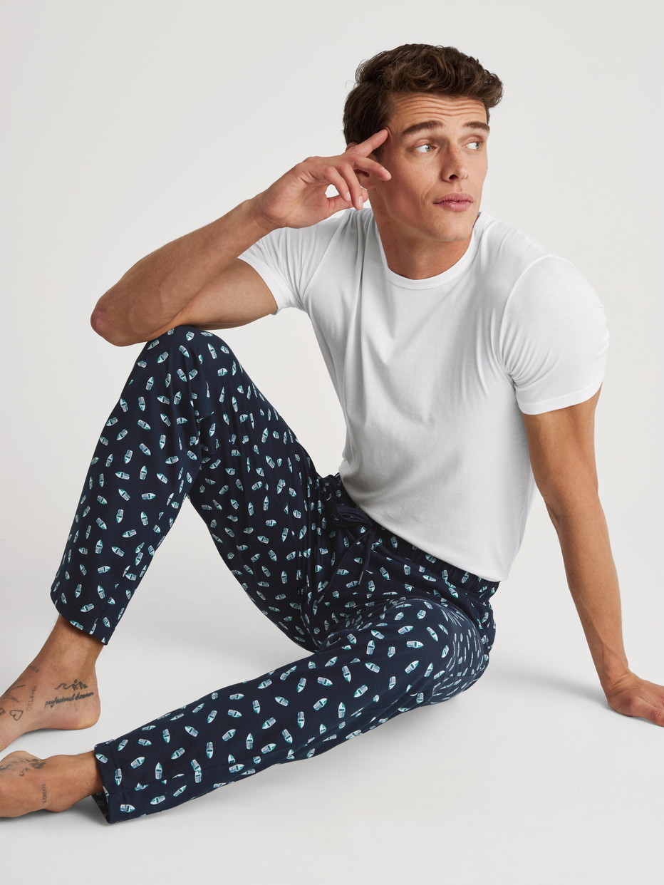 La modella / Il modello Uomo indossa Pantaloni da notte con tasche in 100% cotone di colore Blu, Motivo, della serie RMX Sleep Weekend di CALIDA, Immagine aggiuntiva