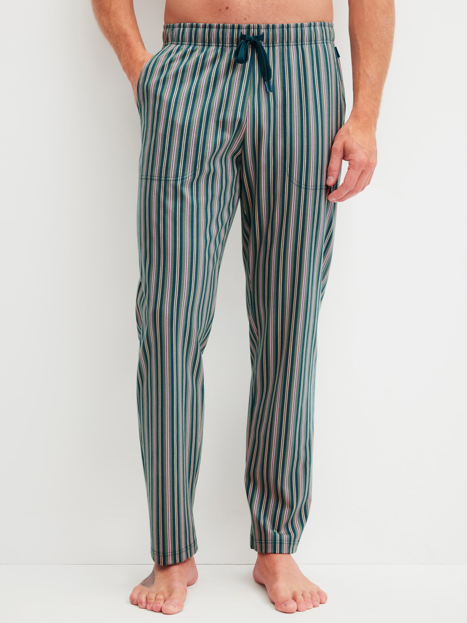 Herren-Model trägt Pyjamahose mit Seitentaschen aus 100% Baumwolle in Grün, Gestreift aus Serie RMX Sleep Leisure von CALIDA, Vorderansicht