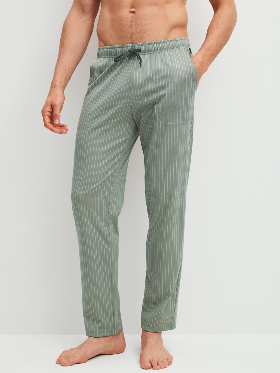 Herren-Model trägt Pyjamahose mit Seitentaschen aus 100% Baumwolle in Grün, Einfarbig aus Serie RMX Sleep Leisure von CALIDA, Vorderansicht
