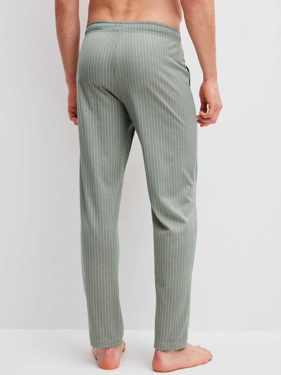 Herren-Model trägt Pyjamahose mit Seitentaschen aus 100% Baumwolle in Grün, Einfarbig aus Serie RMX Sleep Leisure von CALIDA, Rückansicht