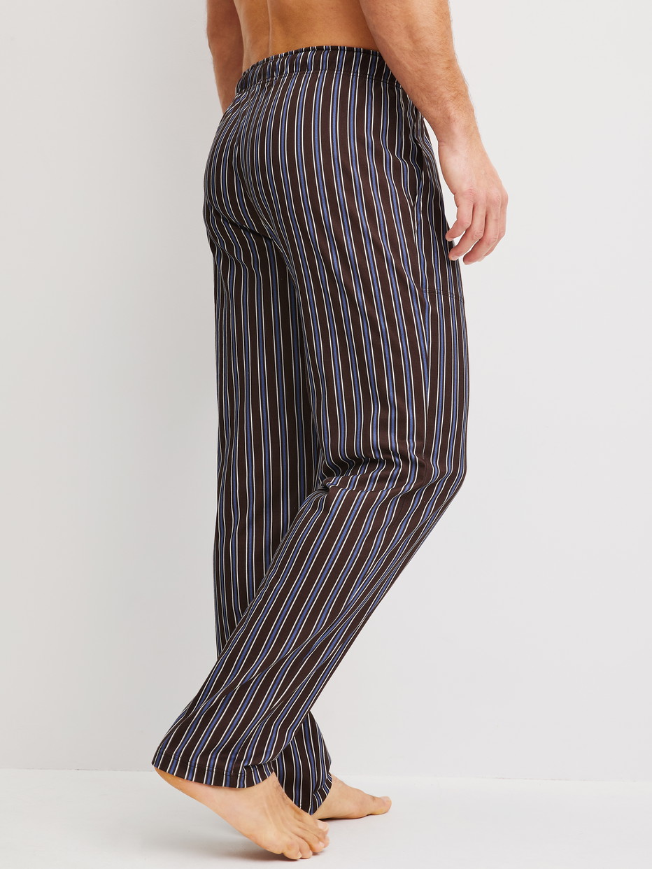 Herren-Model trägt Pyjamahose mit Seitentaschen aus 100% Baumwolle in Braun, Gestreift aus Serie RMX Sleep Weekend von CALIDA, Rückansicht