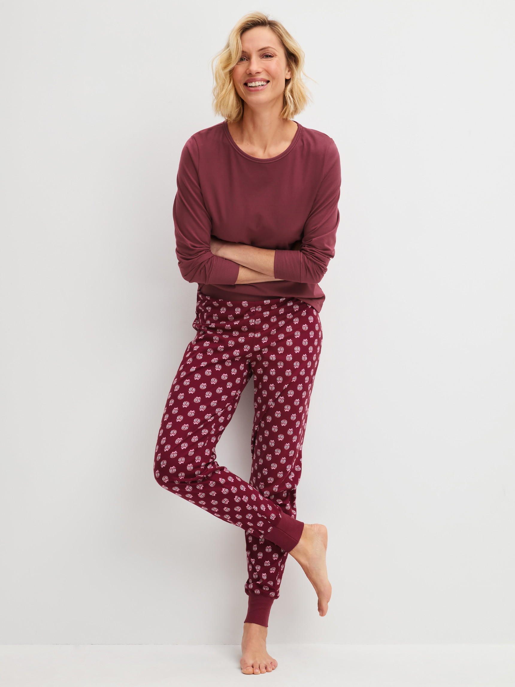 Damen-Model trägt Pyjamahose mit Bündchen aus 100% Baumwolle in Rot, Motiv aus Serie PJ Party M&M von CALIDA, Outfit