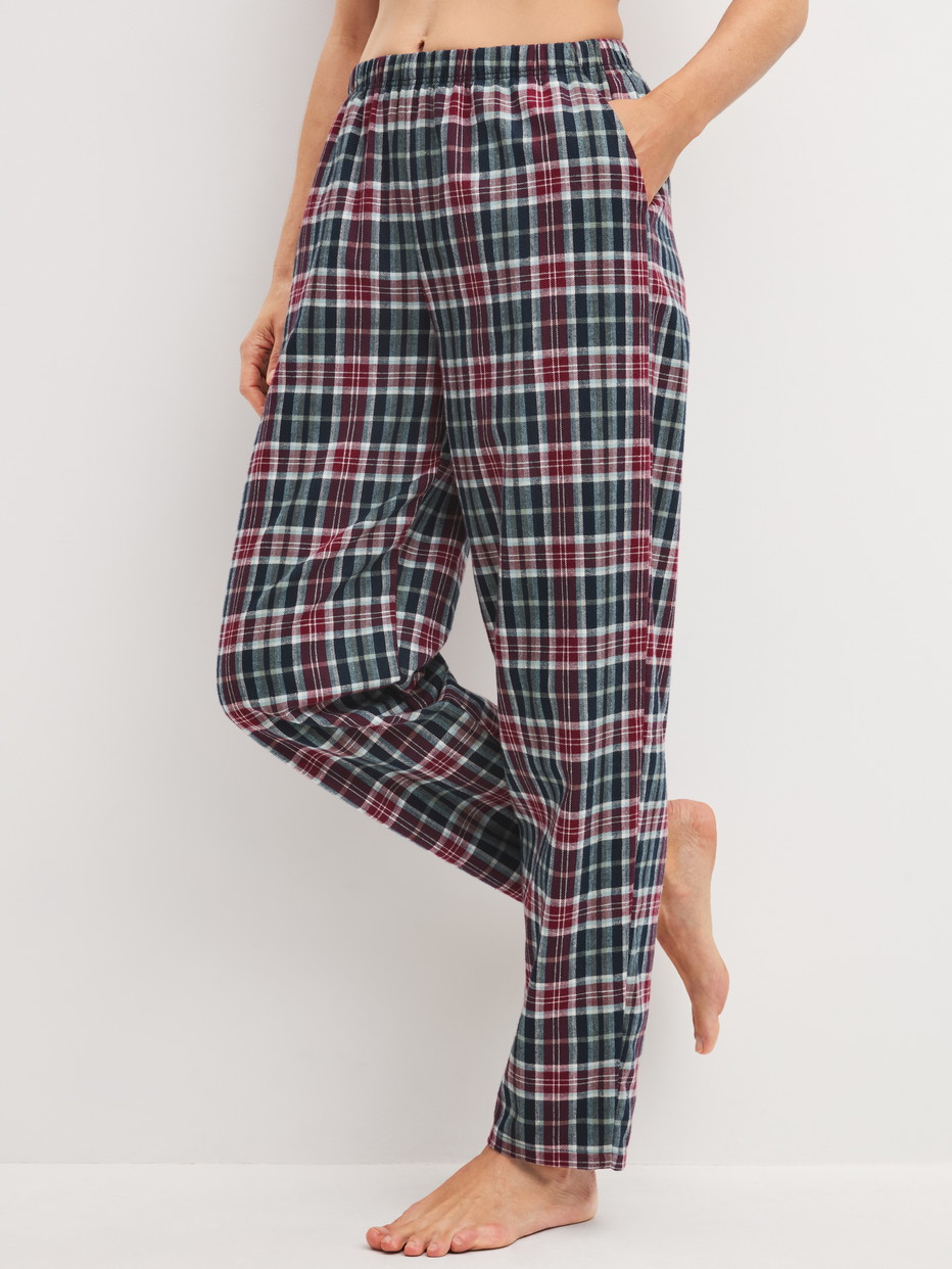 La modella / Il modello Donna indossa Pantaloni in flanella con tasche laterali in 100% cotone di colore Blu, A scacchi, della serie PJ Party M&M di CALIDA, Vista frontale